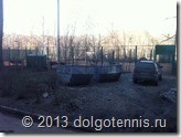 Мусорные контейнеры в двух метрах от теннисного корта.
